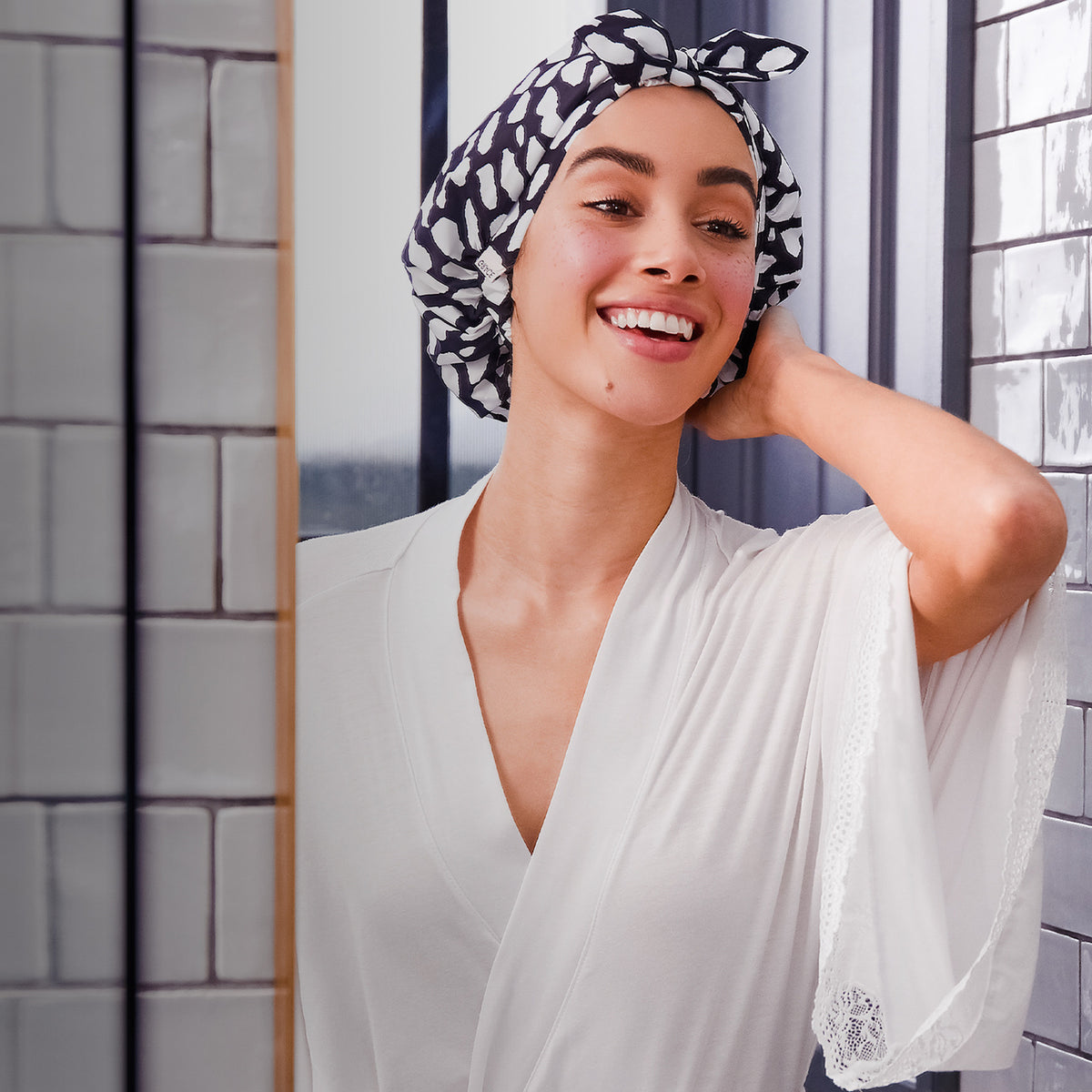 Model wearing the Casablanca shower cap in a tiled bathroom