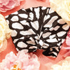 Casablanca shower cap surrounded by coral and ivory flowers, showing the bow and printed fabric